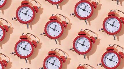 Red clocks in a row on pink background