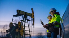 Tradition meets ambition under the watchful gaze of a pumpjack in an oil field.