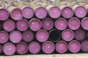 Oil well casing pipe lies on a deck.