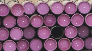 Oil well casing pipe lies on a deck.