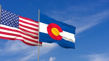USA and Colorado flags over blue sky background. 3D illustration