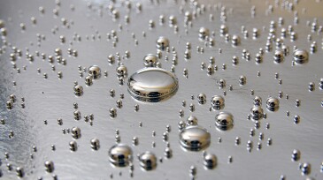 Mercury drops on silver background