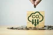 Hand putting coin with carbon reduction icon on heap of coins for carbon dioxide absorption to carbon credit footprint can make money ,limit global warming from climate change concept.