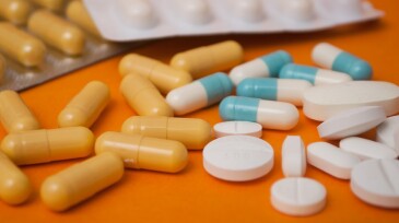 capsules and drug tablets on orange background