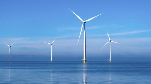 offshore windmill park with clouds and a blue sky