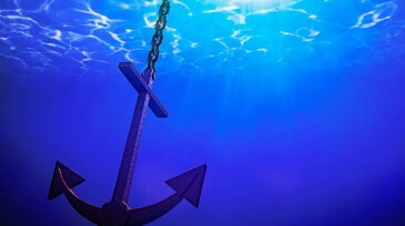 Anchor in the water with sun shining from above