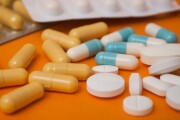 capsules and drug tablets on orange background