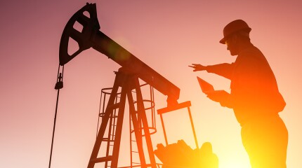 Oil Drill, field pump jack silhouette with setting sun and worker.