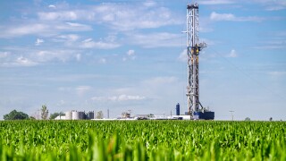 Close shot of a drilling Fracking Rig in a corn field.