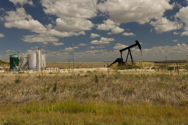 Oil well pump jack against dramatic cloudy sky