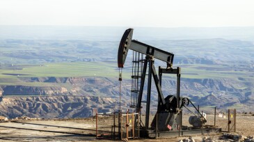 View of the pumpjack in the oil well of the oil field. The arrangement is commonly used for onshore wells producing little oil. Pumpjacks are common in oil-rich areas.