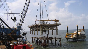 The topsides are lifted up from a platform being decommissioned in the Gulf of Mexico.