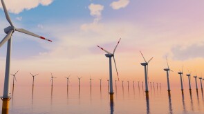 3D Rendering of Giant wind turbines farm located in the open sea, sunset shot. Concept of renewal energy using windmills