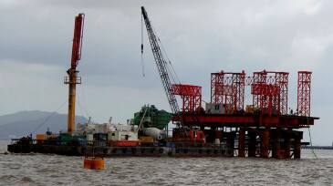red oil platform with crane in the sea