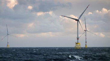 Large offshore 8MW wind turbines, wind farm on the horizont in sunset in north sea