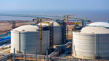 Many neatly arranged large cylindrical storage tanks
