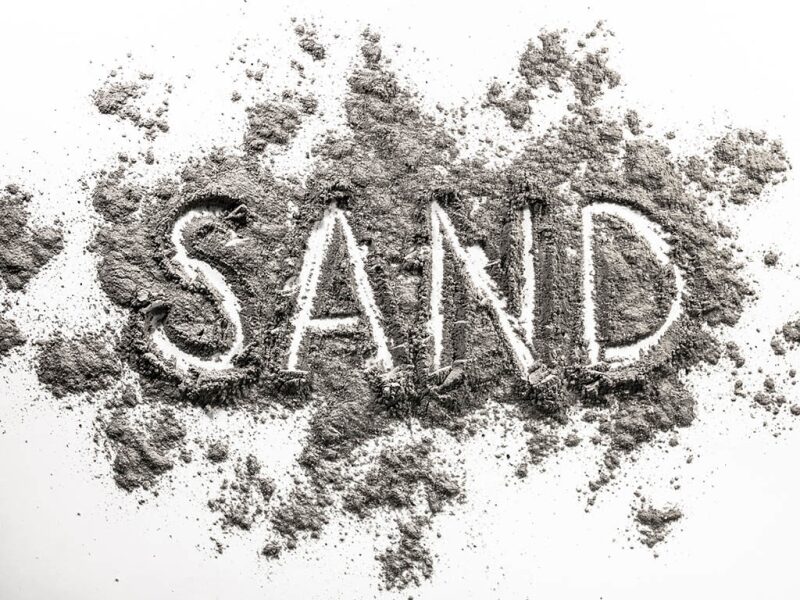 Word "sand" written with sand