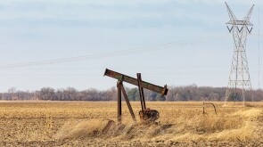 Old, orphaned oil well pump in farm field.  oil well abandonment, decommission, and oil production concept