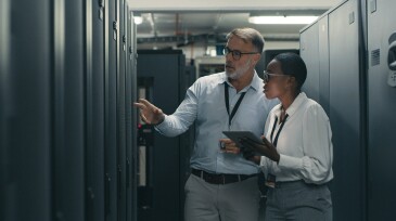 Shot of a man and woman using a digital tablet while working in a data centre