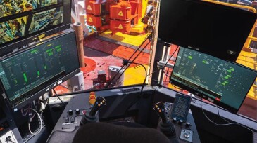 The view of the drilling floor and control panel in the driller’s cabin of a Huisman rig.
