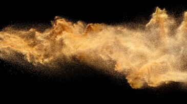 Dry river sand explosion.Brown color sand splash against black background.