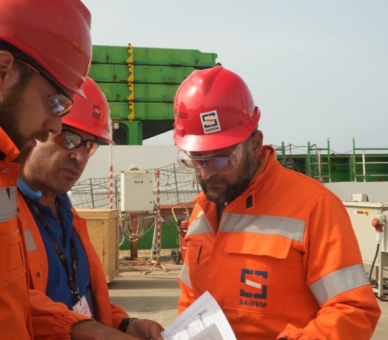 Saipem workers examining documents