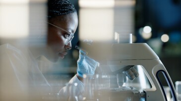 Scientist, microscope and analysis in lab for healthcare, innovation and development in stem cell research. Black woman, investigation and experiment with biotech for dna, exam or test for bacteria