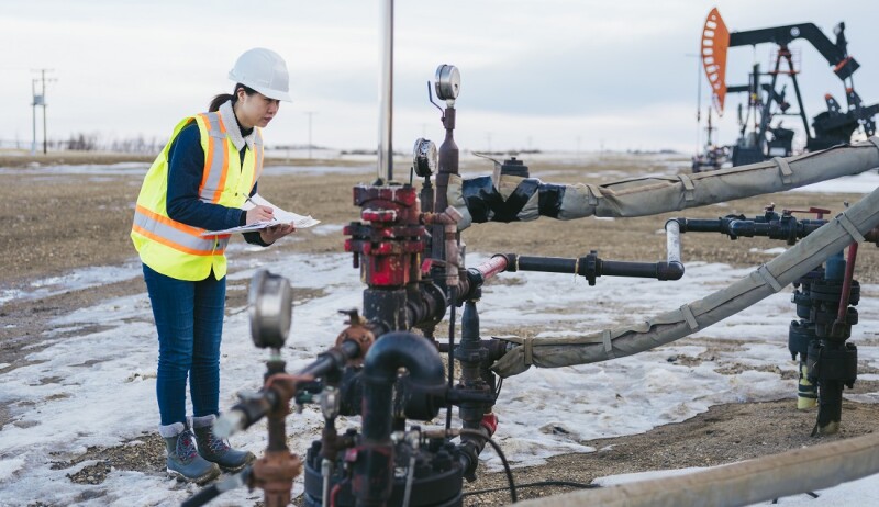 Female Oil Worker at oil field with folder