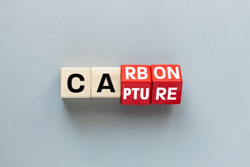 Carbon capture symbol. Turned wooden cubes and changed the concept word Carbon to Capture. Beautiful grey background  Business ecological concept. flat lay, Copy space