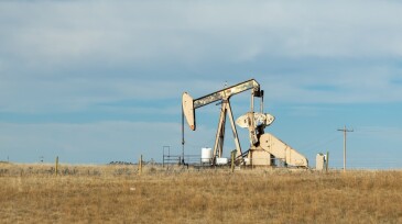 Oil drilling pump jack rig in a field