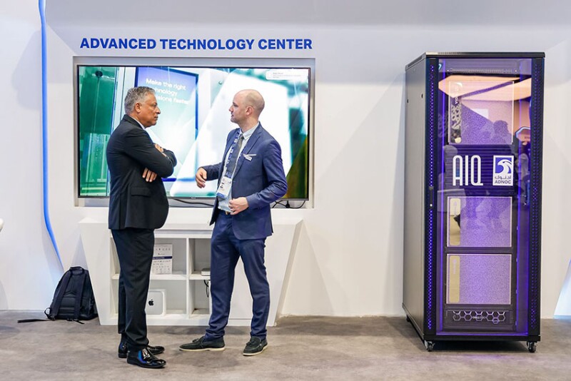 Conference participants converse next to the hottest new technology in the oil and gas industry, a server rack full of powerful chips that enable generative artificial intelligence. Source: ADIPEC.