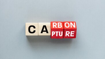 Carbon capture symbol. Turned wooden cubes and changed the concept word Carbon to Capture. Beautiful grey background  Business ecological concept. flat lay, Copy space