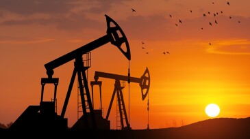 Oil drilling derricks at desert oilfield. The change in oil prices caused by the war. Oil price cap concept.