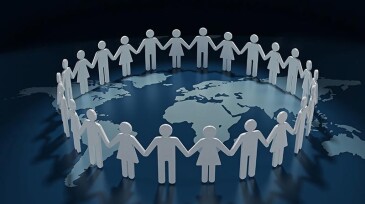 People holding hands in a circle on a world map