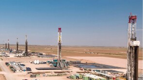 A row of drilling rigs help form what is known as a cube development in the Permian Basin.