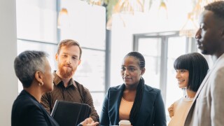 Female leader, manager or CEO in a meeting with her corporate team for planning, strategy and learning. Leadership, management and mentorship with a woman boss and her staff talking in the office