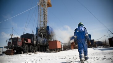 An engineer is walking towards the drilling rig.