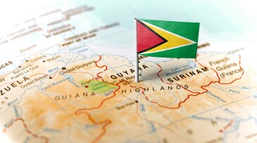 The flag of Guyana pinned on the map. Horizontal orientation. Macro photography.