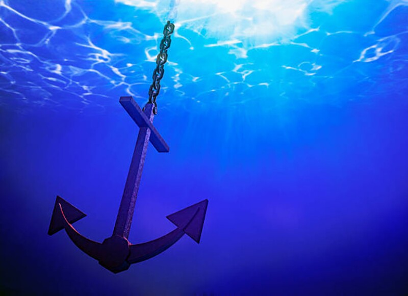 Anchor in the water with sun shining from above