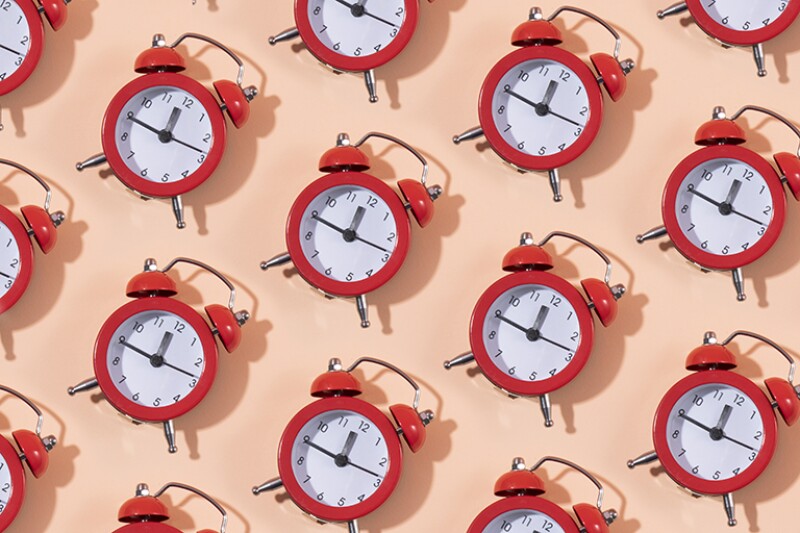 Red clocks in a row on pink background