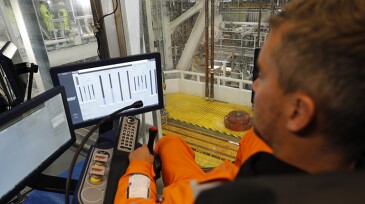 Man in command center with monitors.