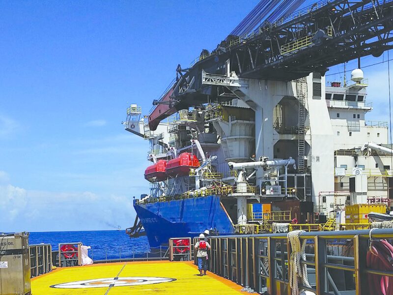Crew member checking on spar being towed