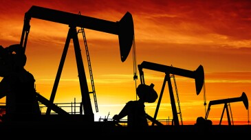 oil pumpjacks in silhouette at sunset, panoramic frame