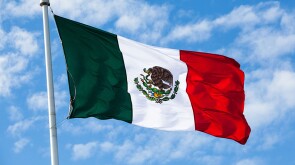 Flag of Mexico waving in the wind, over partly cloudy sky