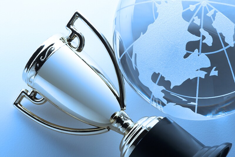 Close-up of silver trophy next to globe focusing on North America.
