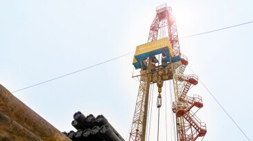Oil and Gas Drilling Rig onshore dessert with dramatic cloudscape. Oil drilling rig operation on the oil platform in oil and gas industry. Land drilling rig blue sky.