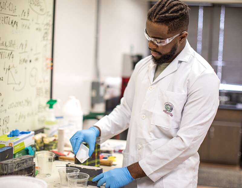 A student works in a hydraulic fracture conductivity laboratory.