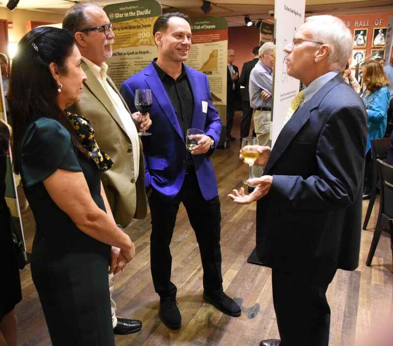 Fig. 2—Panels on display (shown in the background) at the SPE Board of Directors Reception. Coauthor Tony Richards is shown at the far right.