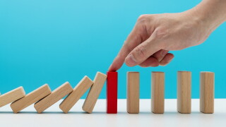 Man hand stopping the dominos falling