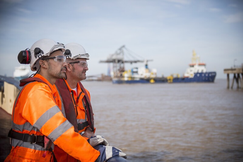 Tug workers looking out to sea on tug